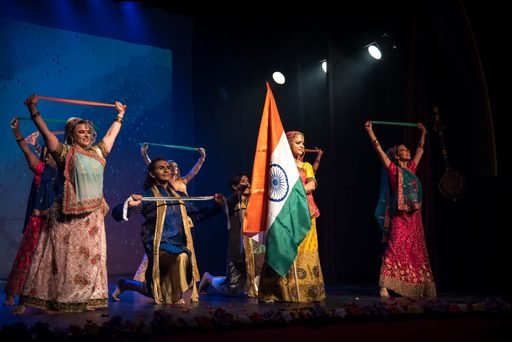 Dancers on stage holding the Indian tricolour