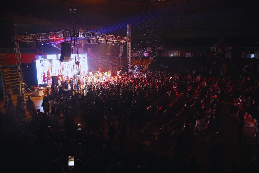 Audience and illuminated stage in a large indoor performance hall