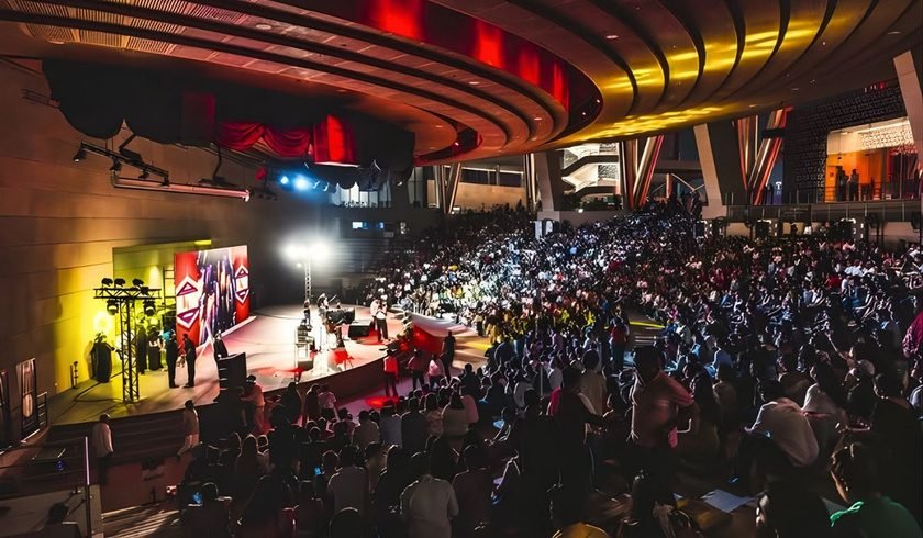 Audience watching performers in a seated auditorium